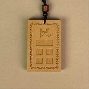 道教风水摆件主图:黄色的「房屋补角牌 (艮)」,中心模铸「艮」字与对应卦象,象征补足艮宫缺角、调和风水气场的文化信仰,对应家中生肖属牛、属虎者,以及小儿子(幼男)。Main image of Taoist Feng Shui ornament: The yellow "Missing Corner Harmony Plaque (Gèn)", molded with the "Gèn" character and corresponding trigram in the center, symbolizing the cultural belief of supplementing the missing corner of the Gèn palace and harmonizing the Feng Shui energy field, corresponding to family members with the Ox or Tiger zodiac signs, as well as the youngest son.