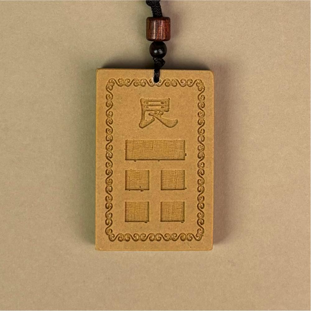 道教风水摆件主图:黄色的「房屋补角牌 (艮)」,中心模铸「艮」字与对应卦象,象征补足艮宫缺角、调和风水气场的文化信仰,对应家中生肖属牛、属虎者,以及小儿子(幼男)。Main image of Taoist Feng Shui ornament: The yellow "Missing Corner Harmony Plaque (Gèn)", molded with the "Gèn" character and corresponding trigram in the center, symbolizing the cultural belief of supplementing the missing corner of the Gèn palace and harmonizing the Feng Shui energy field, corresponding to family members with the Ox or Tiger zodiac signs, as well as the youngest son.