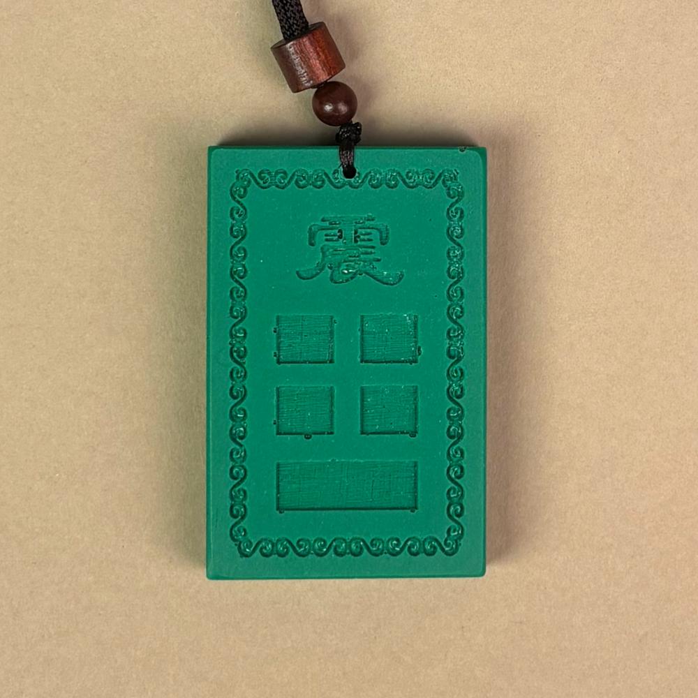 道教风水摆件主图:绿色的「房屋补角牌 (震)」,中心模铸「震」字与对应卦象,象征补足震宫缺角、调和风水气场的文化信仰,对应家中生肖属兔者,以及大儿子(长男)。Main image of Taoist Feng Shui ornament: The green "Missing Corner Harmony Plaque (Zhèn)", molded with the "Zhèn" character and corresponding trigram in the center, symbolizing the cultural belief of supplementing the missing corner of the Zhèn palace and harmonizing the Feng Shui energy field, corresponding to family members with the Rabbit zodiac sign, as well as the eldest son.